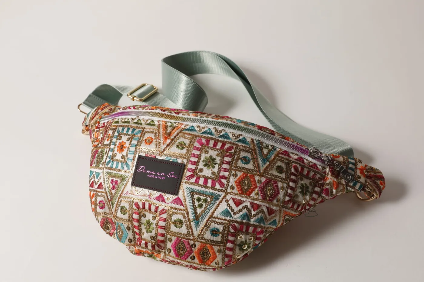 Banane Mosaïque Dame en Soi — sac banane en tissu brodé multicolore à motifs géométriques, sangle vert d'eau, étiquette Made in Paris