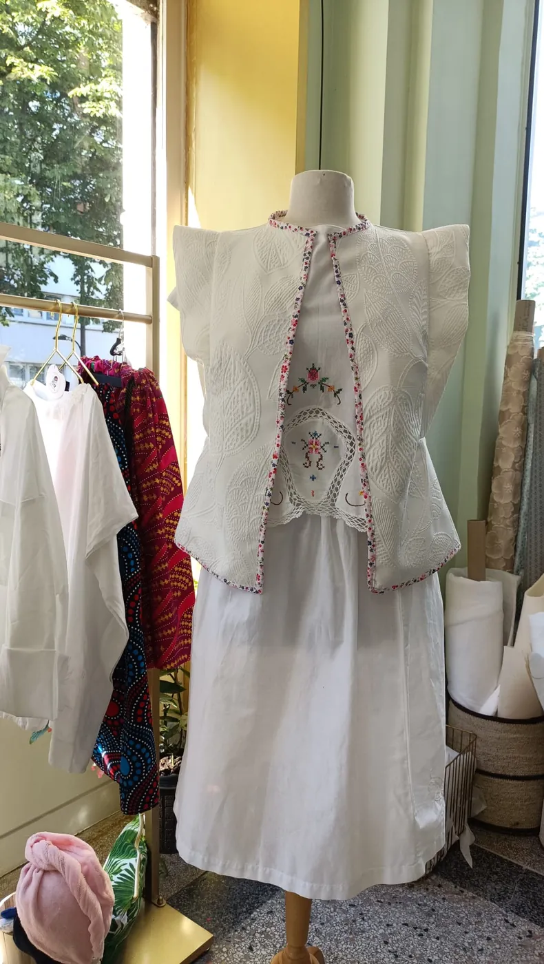 Ensemble Trousseau Dame en Soi — haut blanc à mancherons et broderies fleuries, jupe blanche, présenté en boutique