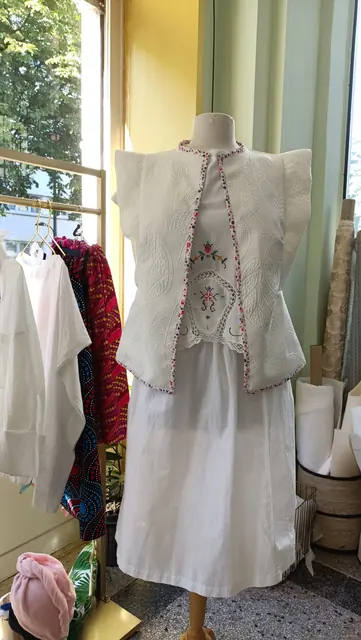 Ensemble Trousseau Dame en Soi — haut blanc à mancherons et broderies fleuries, jupe blanche, présenté en boutique
