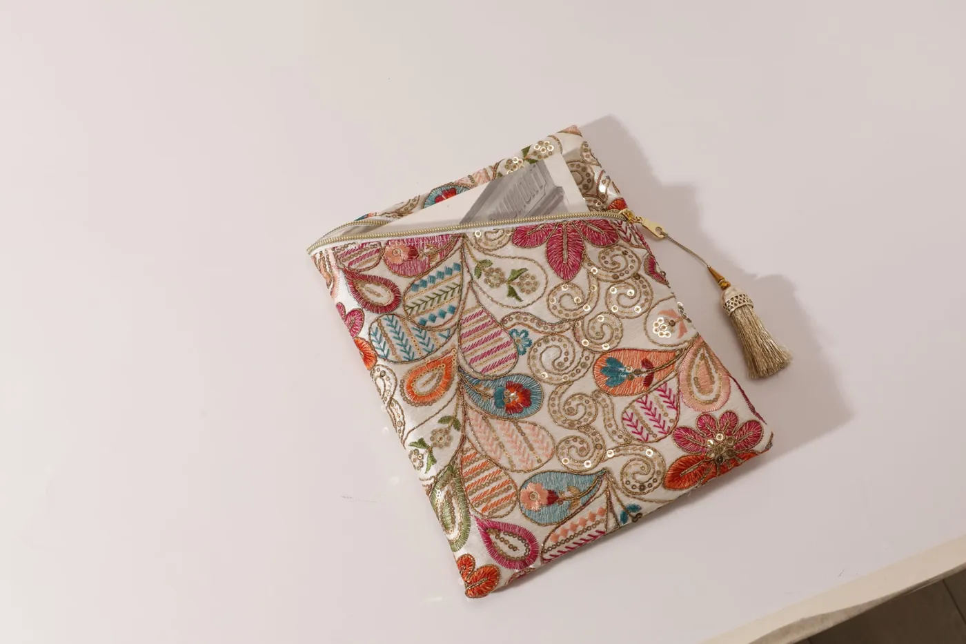 Pochette Pampille Dame en Soi — pochette plate en tissu brodé de fleurs et de motifs cachemire, zip en biais et pompon doré